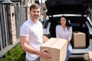 Couple outside car trunk next to boxes