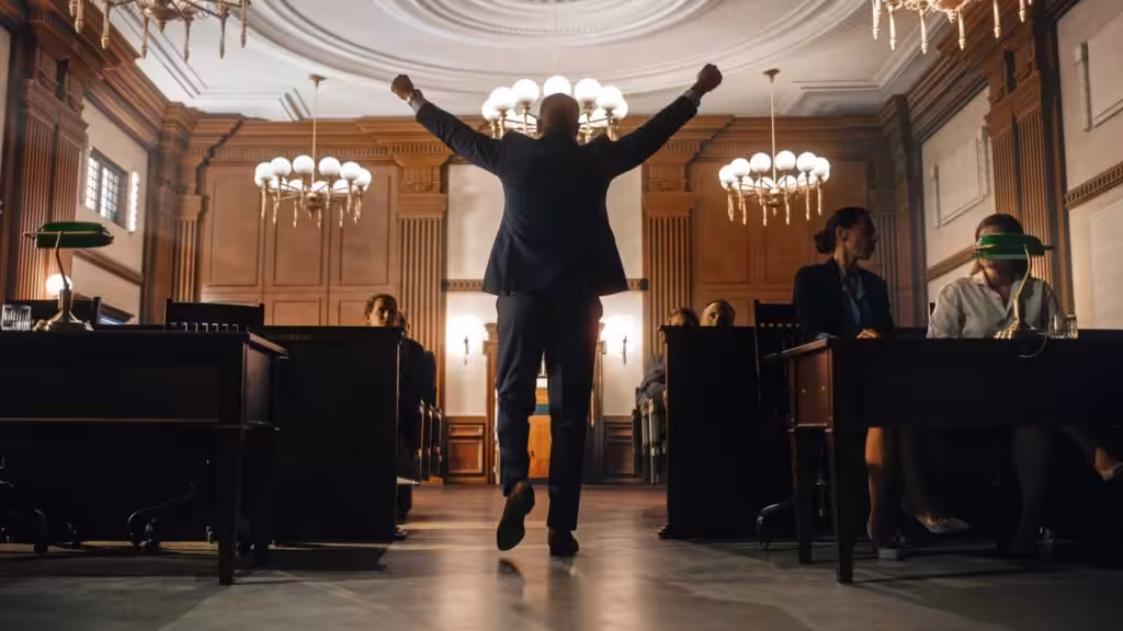 Man facing back with hands up gesture of winning in courtroom