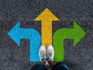 Man standing on road with three arrow choices