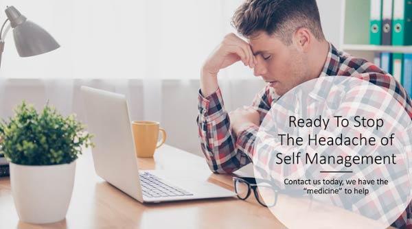 Grimacing man sitting at a table in front of his laptop