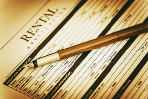 Rental fraud prevention landlord reviewing tenant application documents